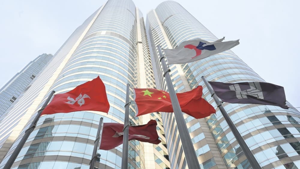 Flags of China, Hong Kong SAR and HKEX flutter above Exchange Square in Hong Kong, Aug 19, 2026. (AFP)