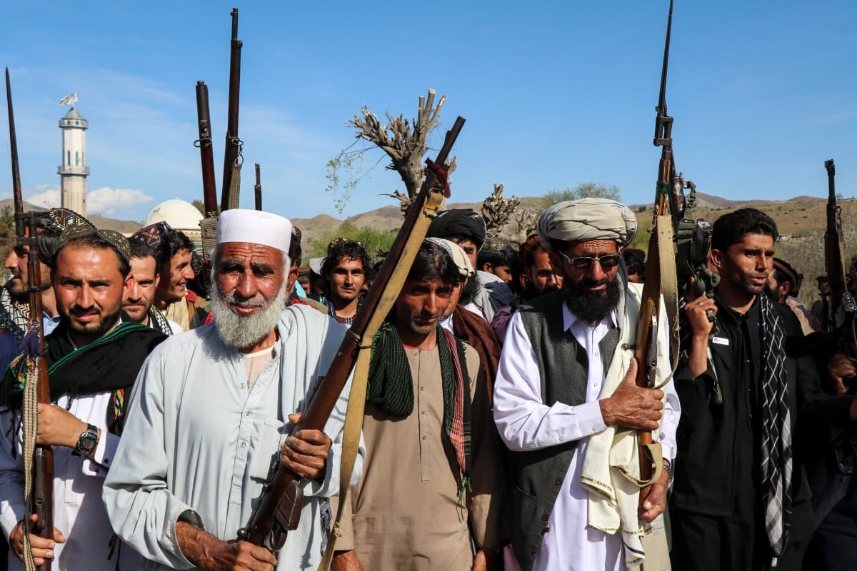 Afghan men armed with guns and rifles march in the Zazai Maidan district of Khost province on March 27, 2026. (AFP)