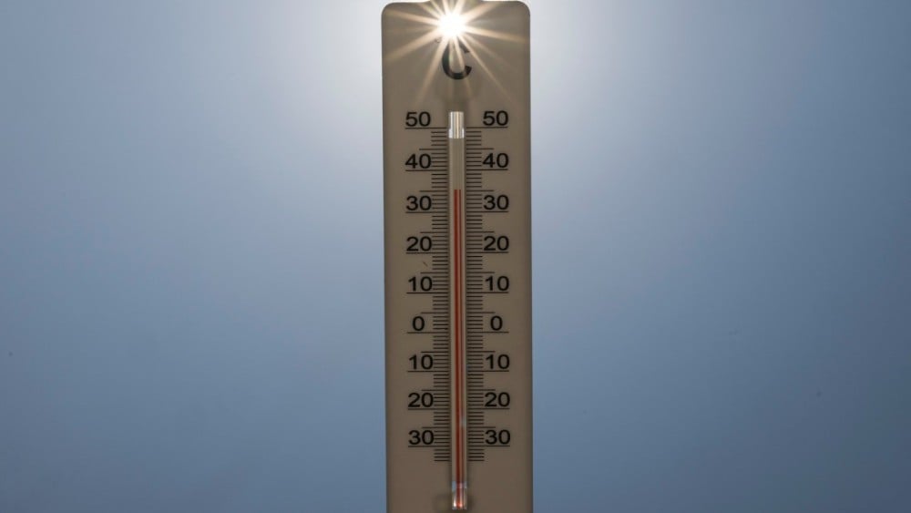 This photograph shows sun rays shining through a handheld house thermometer reading 35 degrees Celsius, in Montreuil on the afternoon of August 14, 2025, amid a heatwave in Europe.