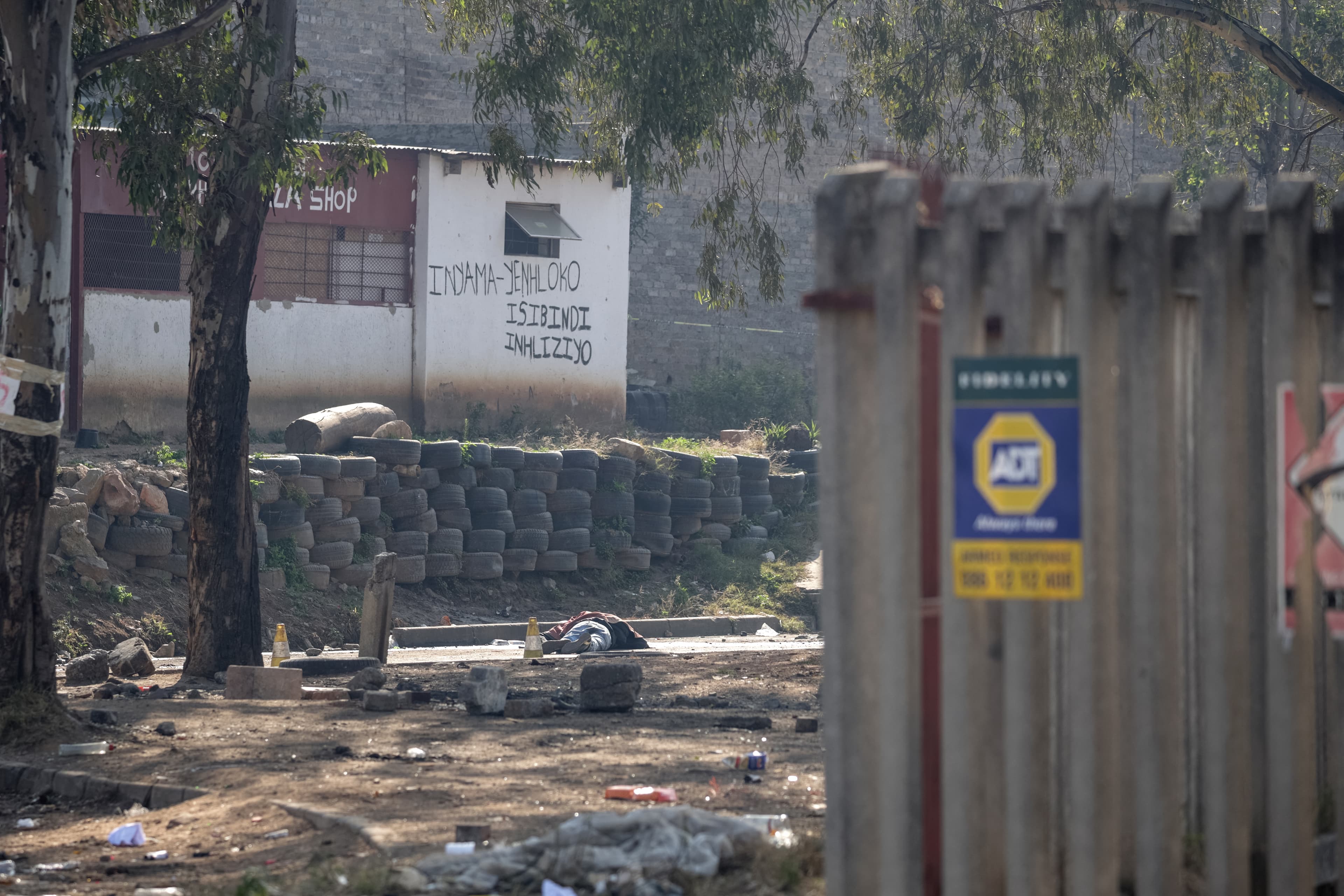 Graphic content / TOPSHOT - A general view of a body of a victim laying in the road at Jumpers informal settlement in Cleveland, east of Johannesburg, on June 10, 2026.