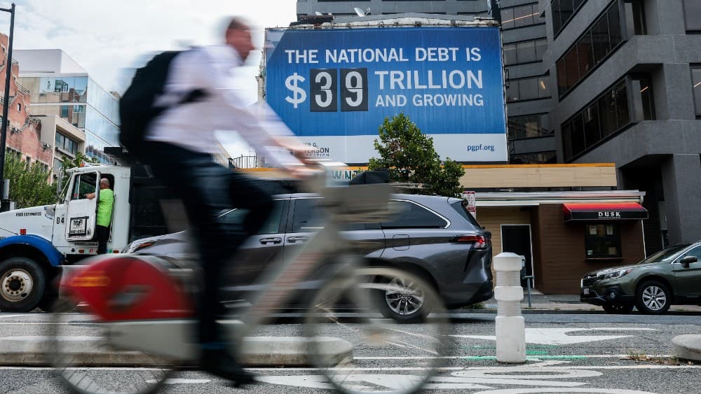 WASHINGTON, DC - AUGUST 20: A sign displaying national debt hangs from a building in Foggy Bottom on August 20, 2026 in Washington, DC. Signs have been put up across the country made by the nonpartisan Peter G. Peterson Foundation. Anna Moneymaker/Getty I