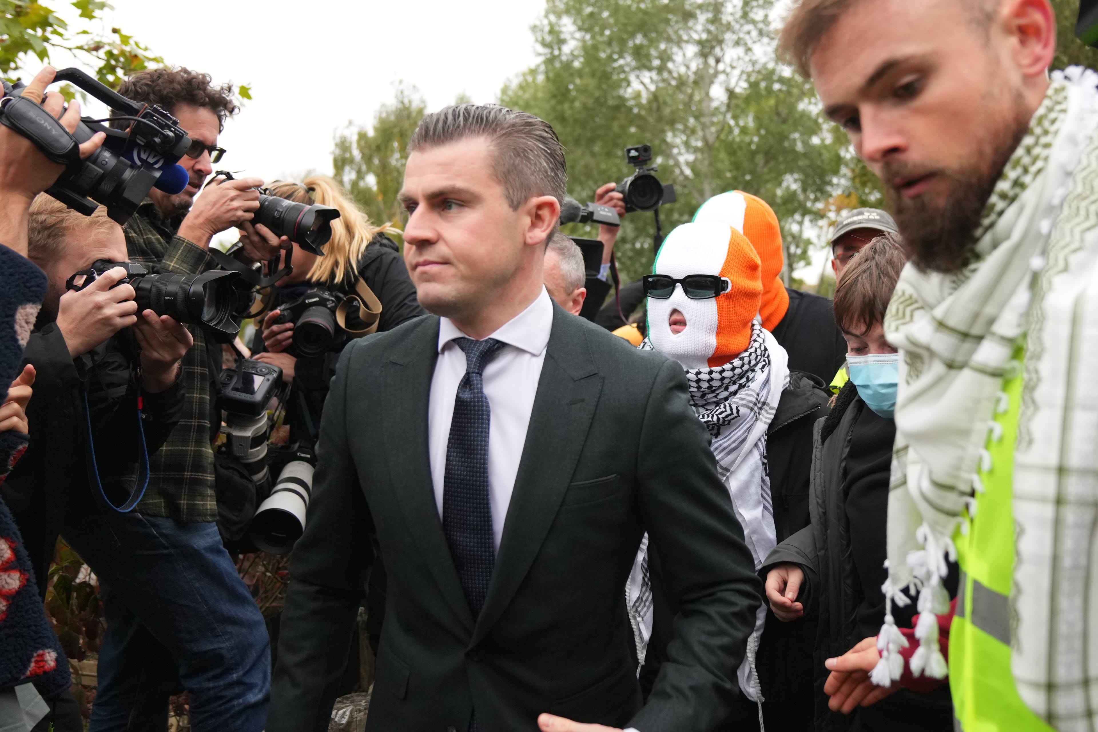 person believed to be Liam Óg Ó hAnnaidh, aka Mo Chara, in a mask, a member of the Irish language band Kneecap, arrives at Woolwich Crown Court in London, Friday