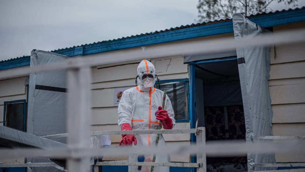 A hygienist wearing personal protective equipment (PPE) begins cleaning and disinfection operations at the Rwampara Ebola Treatment Centre (ETC) in Bunia, Ituri, in the east of the Democratic Republic of Congo on July 13, 2026. (AFP)