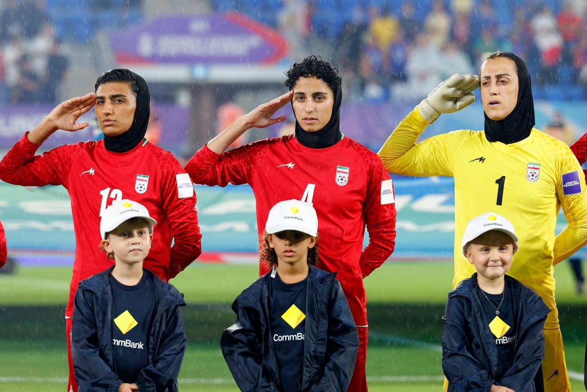 Iranian players, goalkeeper Raha Yazdani (R), Melika Motevalli (C) and Fatemeh Amineh, salute during the national anthem before the AFC Women's Asian Cup Australia 2026 football match between Iran and Philippines in Gold Coast on March 8, 2026. (AFP)
