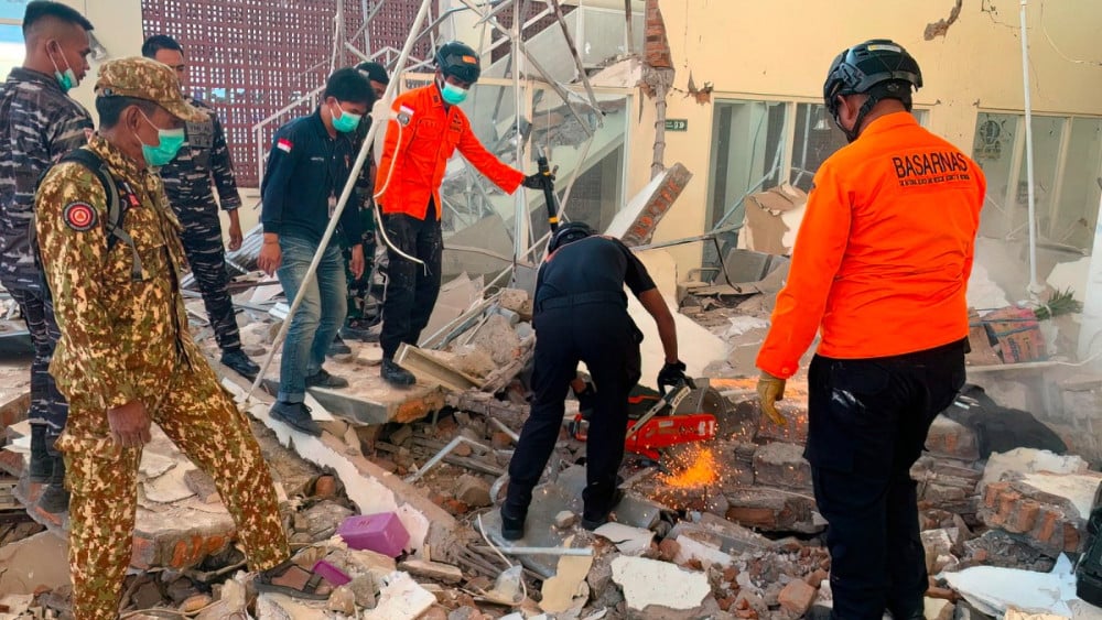 This handout picture taken and released on August 15, 2026 by Indonesia's National Search and Rescue Agency (BASARNAS) shows rescuers working amid the rubble of a damaged building after an earthquake in Maumere, East Nusa Tenggara. (AFP)