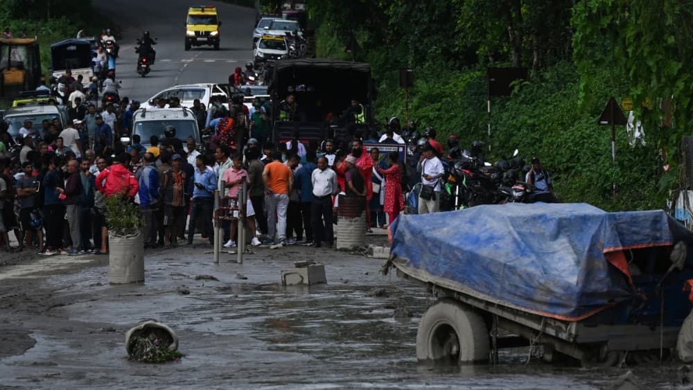 Residents look at a street submerged by mud following flash floods and a landslide disaster in Devighat, in Nepal's Nuwakot district on August 26, 2026. (Photo: AFP)