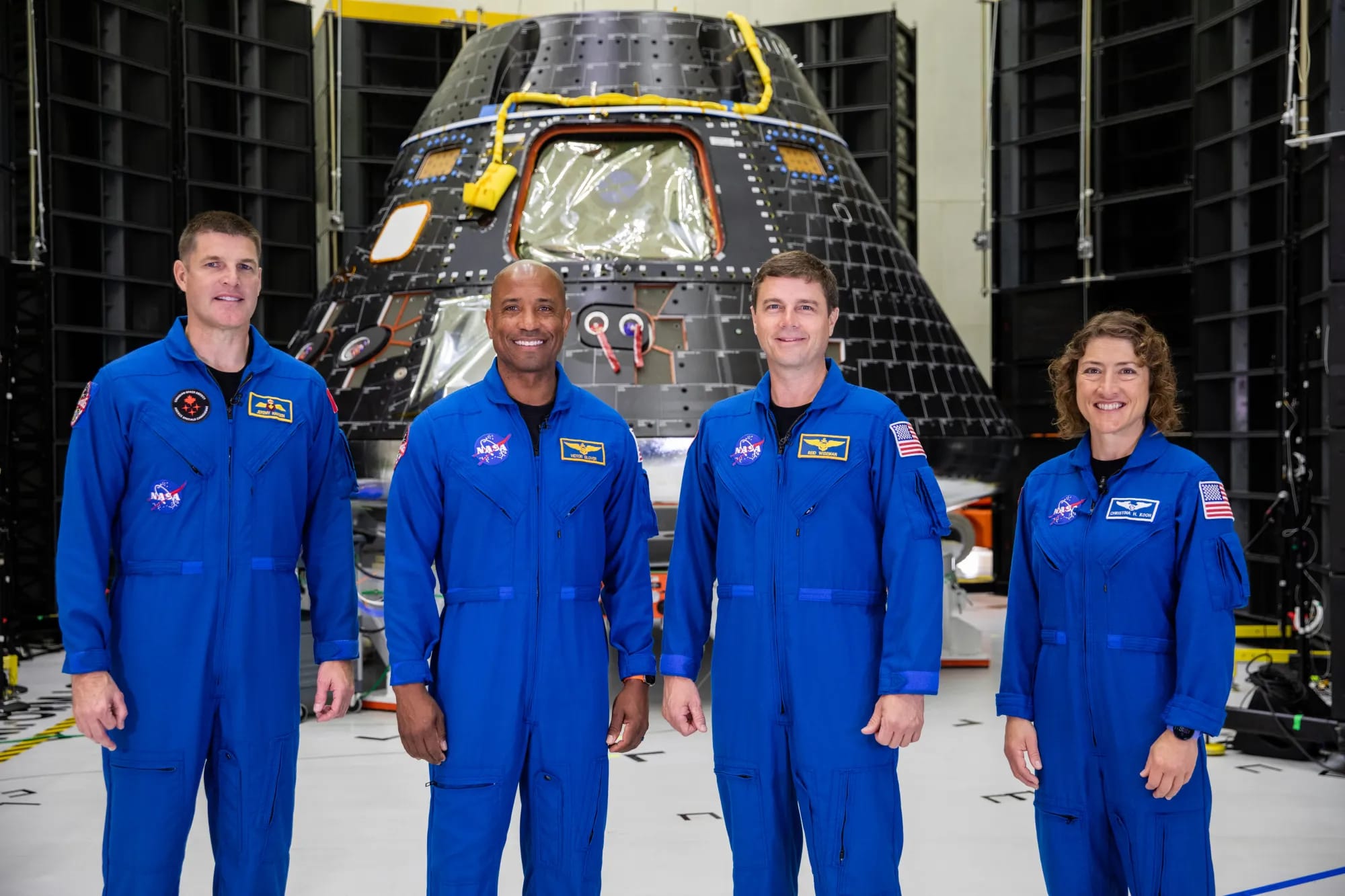 The Artemis II crew is shown inside the Neil Armstrong Operations and Checkout Building at NASA’s Kennedy Space Center in Florida in front of their Orion crew module on Aug. 8, 2023. From left are: Jeremy Hansen, mission specialist; Victor Glover, pilot;