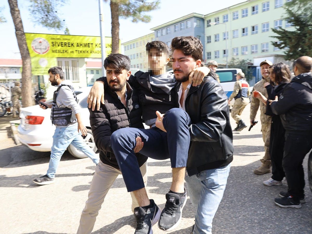 This handout photograph, taken and released on April 14, 2026, by Turkish news agency DHA (Demiroren News Agency), shows an injured student evacuated as special force security surrounds the school in southeastern Turkey. (AFP)