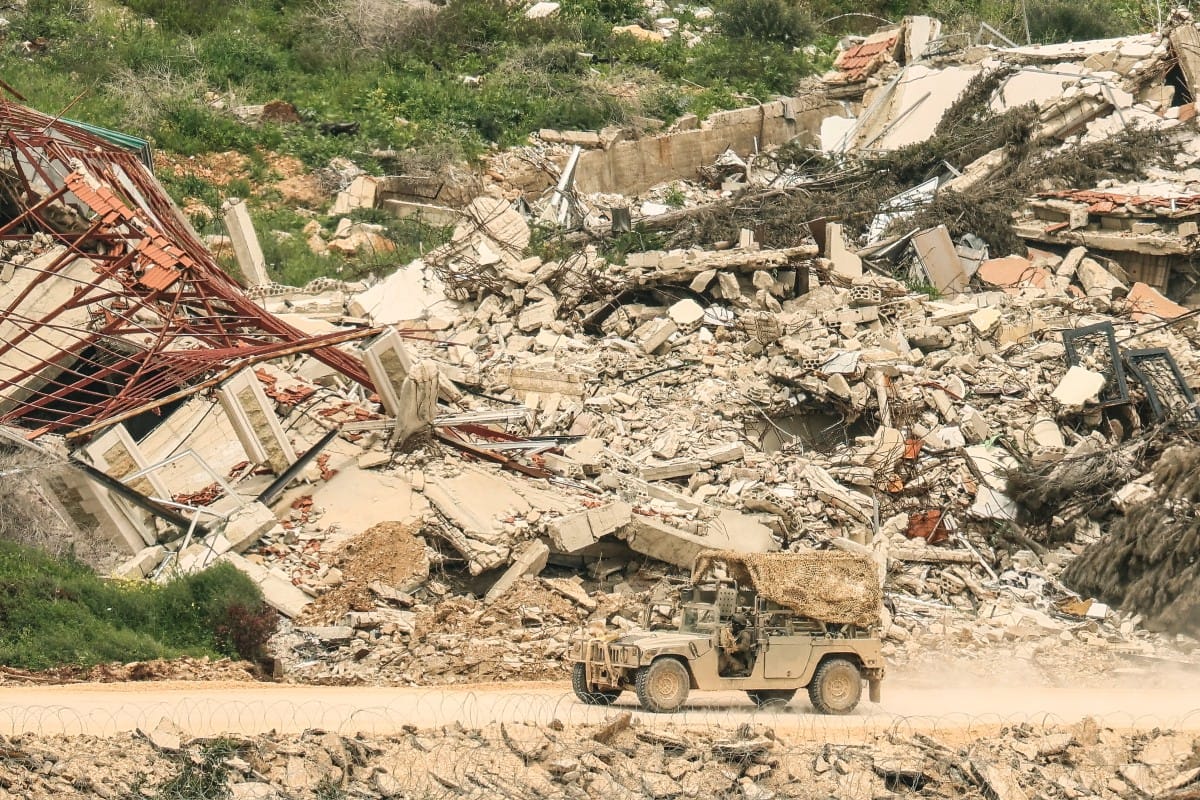 A photograph taken from the Israeli side of the border with Lebanon shows Israeli soldiers driving along a road running beside destroyed buildings in southern Lebanon on April 15, 2026. (AFP)