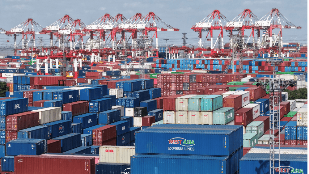 An aerial view shows stacked containers at the Shanghai Port container terminal in Shanghai on December 8, 2025. (Photo by AFP/File)