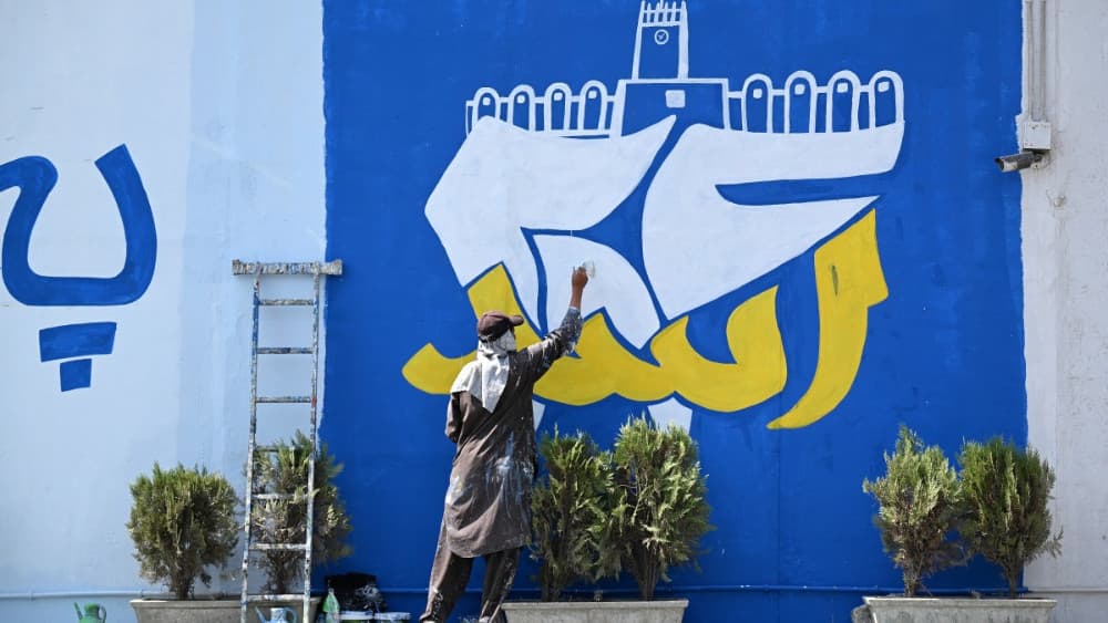 An Afghan man paints a mural commemorating the fifth anniversary marking the Taliban's return to power, along a street in Kabul on August 13, 2026. (AFP)