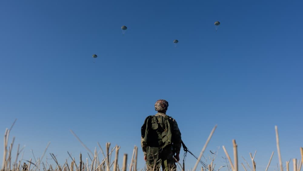 A Ukrainian serviceman of the Air Assault Forces watches the parachutists land during parachute jump training in an undisclosed location on August 12, 2026, amid the Russian invasion of Ukraine. (Photo: AFP)